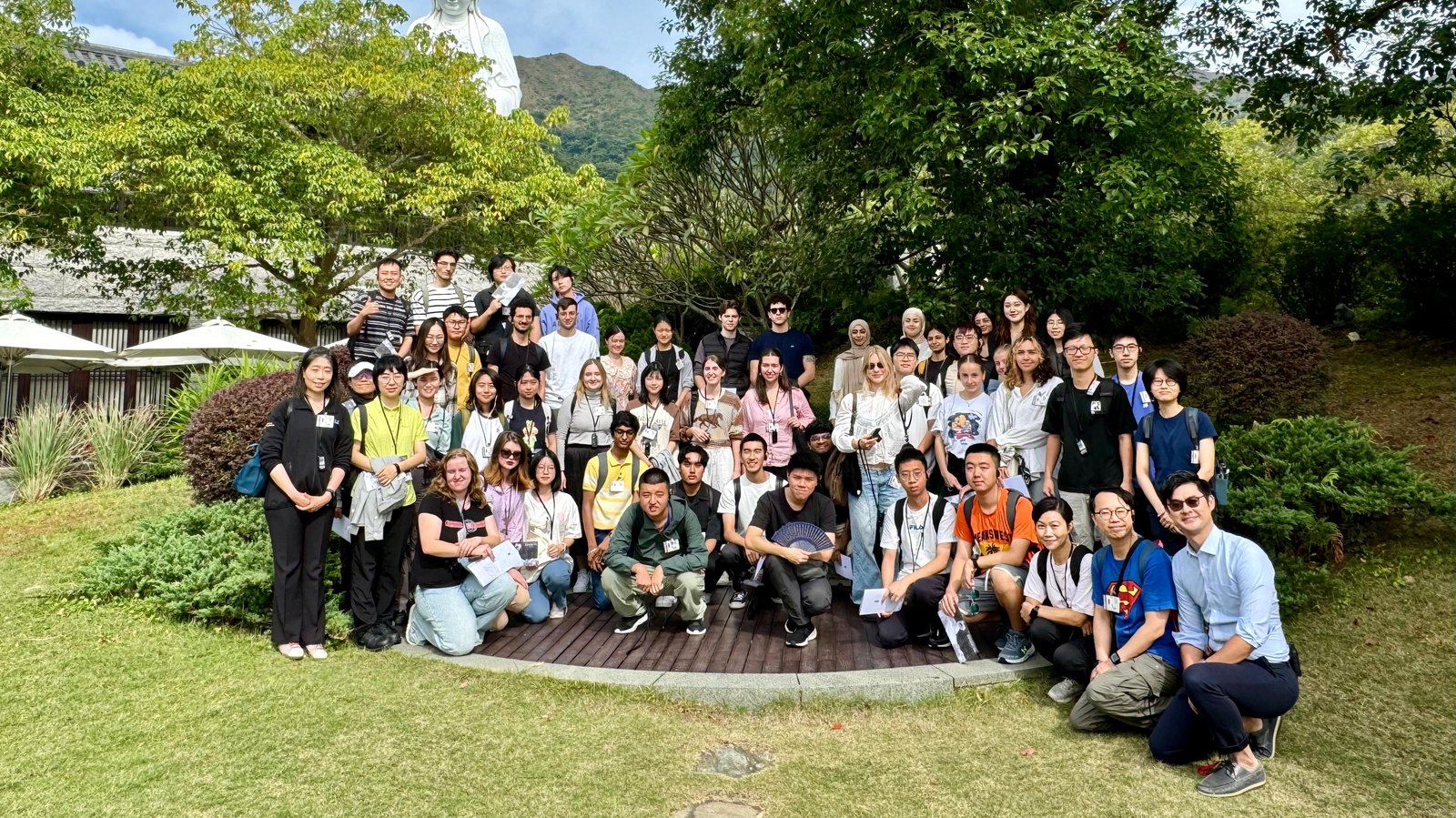 A large group of students and staff on a residence outing, photographed together in a garden